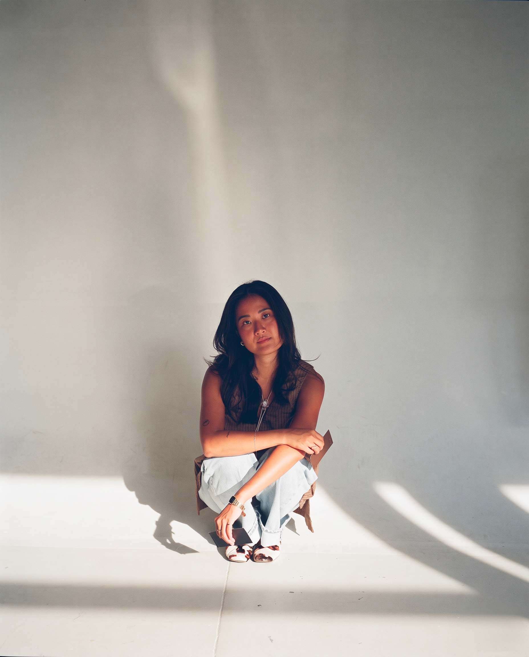 Woman seated in soft daylight holding a color swatch