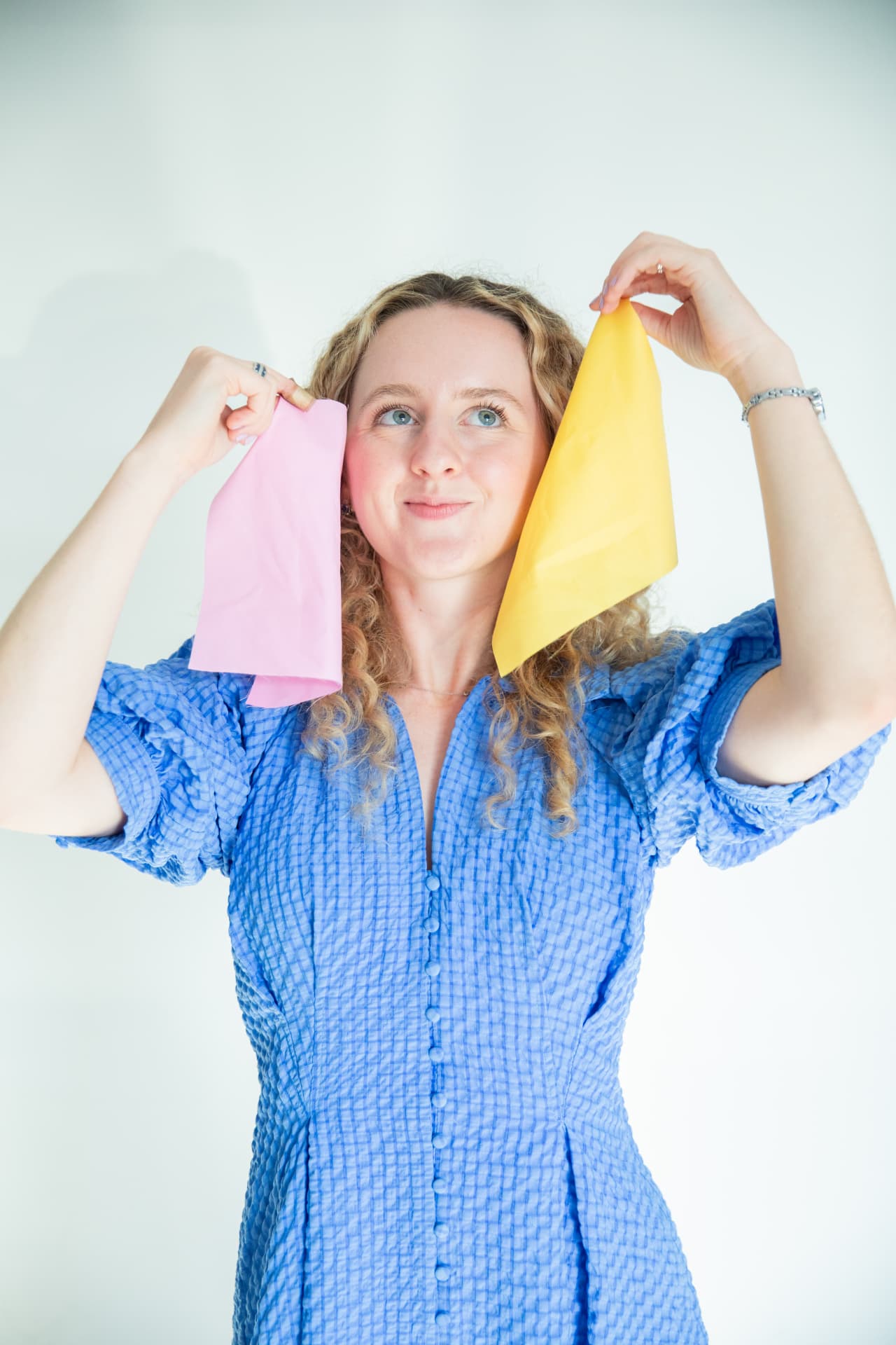 Holding pink and yellow fabric up to the face to test undertone