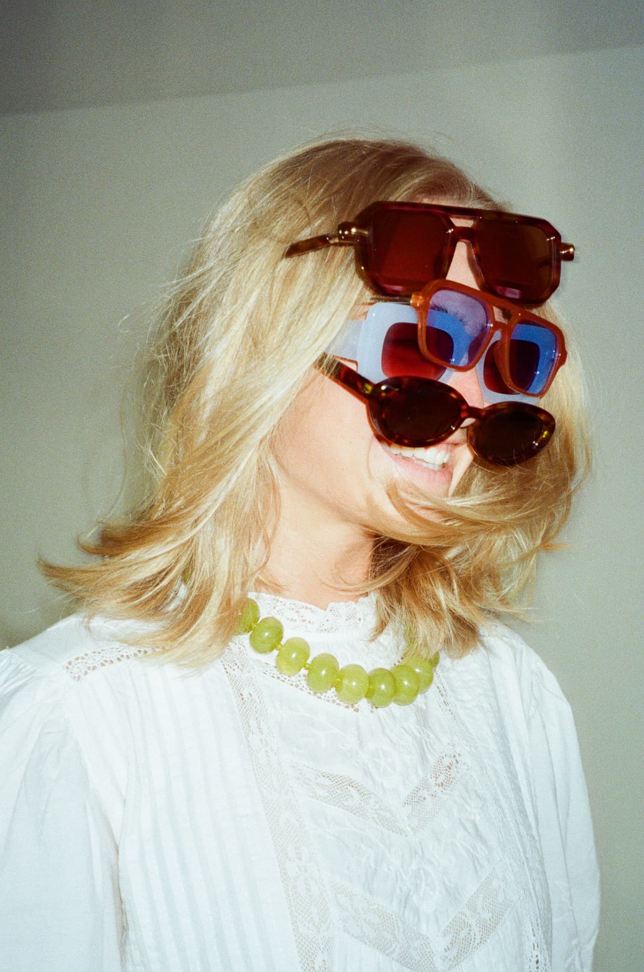 Stacked sunglasses and a pistachio bead necklace